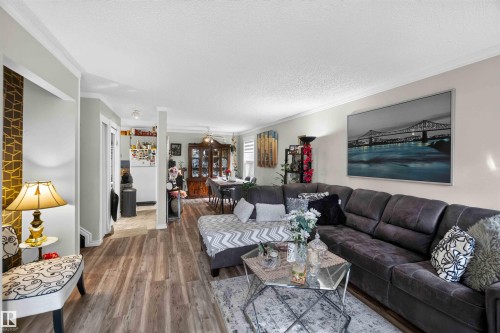 Wood-finish flooring, crown molding, and bright recessed lighting - 17127 109 Street Nw, Edmonton, AB - Indoor Photo Showing Living Room