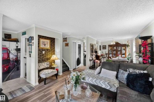Wood-finish flooring throughout, featuring crown molding and trim - 17127 109 Street Nw, Edmonton, AB - Indoor Photo Showing Living Room