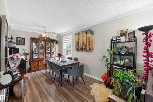 Wood-finish flooring throughout, ceiling fan with integrated lighting, and a large window with privacy blinds - 17127 109 Street Nw, Edmonton, AB - Indoor Photo Showing Dining Room