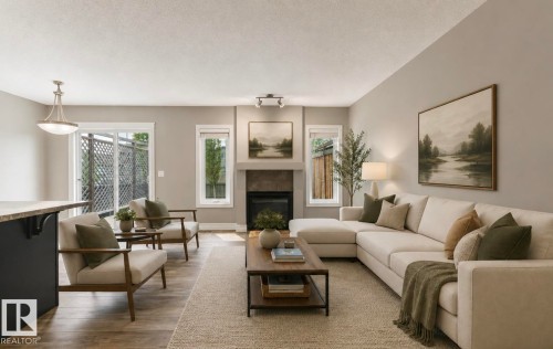 Living area featuring wood-finish flooring, a fireplace with a dark tile surround, a built-in mantel, and a sliding glass door - 79 Catalina Crest, Fort Saskatchewan, AB - Indoor Photo Showing Living Room With Fireplace