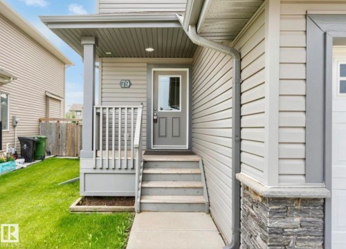 Front entry with covered porch, horizontal siding, stone veneer accent, and concrete steps - 79 Catalina Crest, Fort Saskatchewan, AB - Outdoor With Exterior