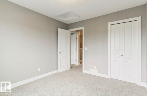 Plush carpeting, neutral wall color, white trim, paneled interior door, and a bi-fold closet door - 79 Catalina Crest, Fort Saskatchewan, AB - Indoor
