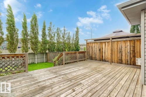 Expansive wood deck with lattice railing, wooden privacy fence, and manicured lawn beyond - 79 Catalina Crest, Fort Saskatchewan, AB - Outdoor With Deck Patio Veranda With Exterior