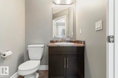 Dark wood-finish vanity with a surface-mounted sink and a stone-finish countertop - 79 Catalina Crest, Fort Saskatchewan, AB - Indoor Photo Showing Bathroom