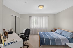 Bedroom featuring light-colored walls, carpet flooring, and a ceiling-mounted light fixture - 