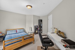 Carpeted bedroom with neutral wall paint, overhead flush-mount lighting, and a white interior door - 