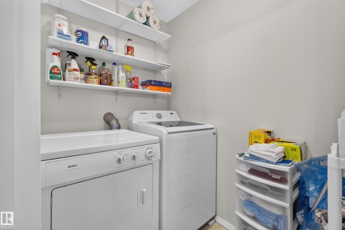 Dedicated laundry area featuring a white top-load washer and front-load dryer - #105 10421 42 Av Nw, Edmonton, AB - Indoor Photo Showing Laundry Room