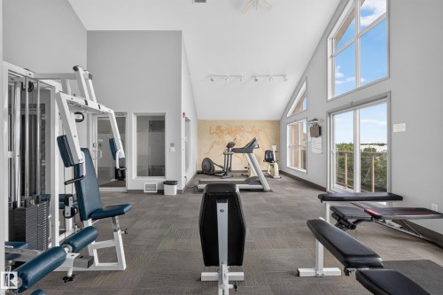 Fitness center featuring vaulted ceilings with exposed beams and track lighting - #105 10421 42 Av Nw, Edmonton, AB - Indoor Photo Showing Gym Room
