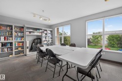 Spacious room featuring multiple large windows, track lighting, extensive built-in shelving, and carpet tile flooring - 