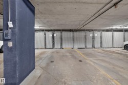 Dedicated storage units within the concrete parking garage, featuring durable chain-link fencing and numbered gates - 