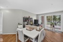 Bright living area featuring wood-finish flooring and light gray walls - #105 10421 42 Av Nw, Edmonton, AB  - Indoor 