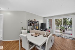 Bright living area featuring wood-finish flooring and light gray walls - 