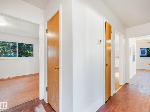 Hardwood-look flooring throughout, solid wood doors, and white walls - 6112 105A Street Nw, Edmonton, AB - Indoor Photo Showing Other Room