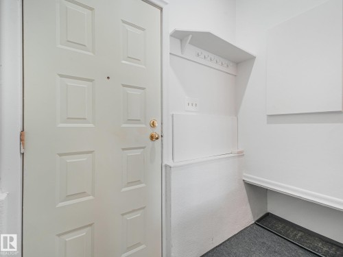 Utility room featuring white cabinetry with open shelving, white refrigerator with freezer compartment, and dark-finish flooring - 6112 105A Street Nw, Edmonton, AB - Indoor