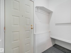Utility room featuring white cabinetry with open shelving, white refrigerator with freezer compartment, and dark-finish flooring - 