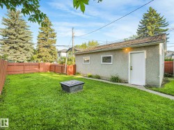 Detached garage with stucco exterior, multiple windows, and a side entry door - 