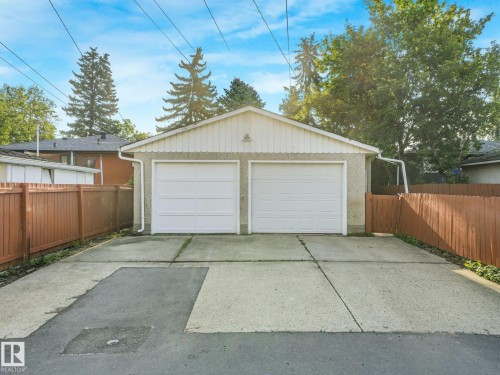 Detached two-car garage with white panel doors and stucco exterior - 6112 105A Street Nw, Edmonton, AB - Outdoor