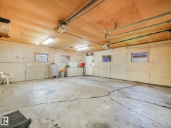Garage with exposed wood ceiling, concrete flooring, and multiple windows - 