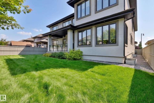 Modern exterior with multiple large windows, covered patio, and a grass lawn - 3644 Westcliff Way Sw, Edmonton, AB - Outdoor