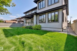 Modern exterior with multiple large windows, covered patio, and a grass lawn - 