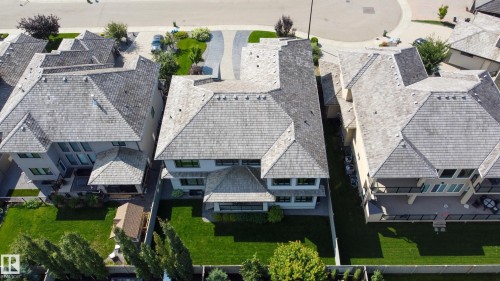 Expansive property featuring a cedar shake roof, stucco exterior, large backyard, and an elevated deck with black railings - 3644 Westcliff Way Sw, Edmonton, AB - Outdoor