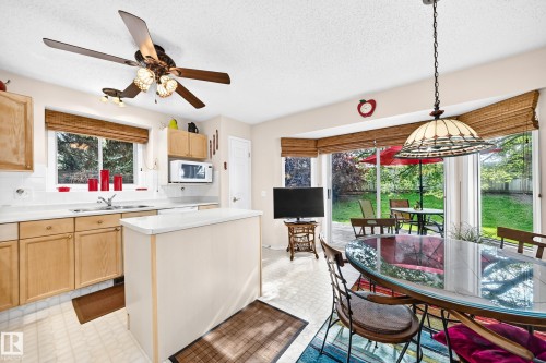 Appreciate the Kitchen island and abundant natural light from large glass sliding doors overlooking the rear landscaped yard - 350 Pearson Crescent Nw, Edmonton, AB - Indoor Photo Showing Kitchen With Double Sink