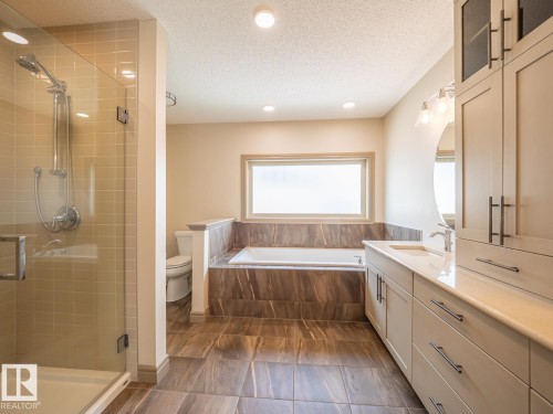 Recessed lighting, glass-enclosed shower, built-in bathtub, dual vanity with undermount sink, and integrated cabinetry - 97 Astoria Point(E), Devon, AB - Indoor Photo Showing Bathroom