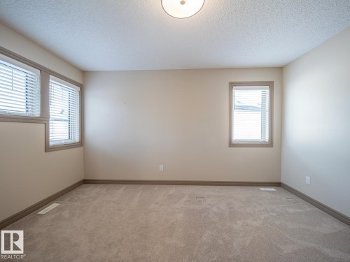 Neutral wall paint, textured ceiling, flush mount ceiling light, and carpeted flooring - 97 Astoria Point(E), Devon, AB - Indoor Photo Showing Other Room
