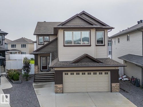 Two-story exterior with multi-toned siding and stone accents - 97 Astoria Point(E), Devon, AB - Outdoor With Facade