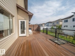 Expansive deck featuring wood-finish planks and a glass panel railing - 
