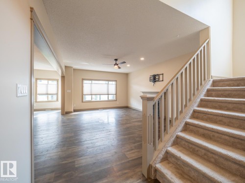 Staircase with wood newel post and carpeted treads, wood-finish flooring, recessed lighting, and a ceiling fan - 97 Astoria Point(E), Devon, AB - Indoor Photo Showing Other Room