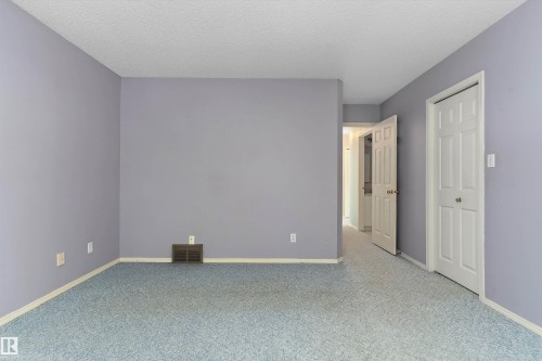 Textured ceiling, painted walls, wall-to-wall carpeting, and white interior doors - 851 112A Street Nw, Edmonton, AB - Indoor Photo Showing Other Room