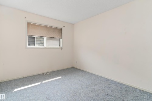 Wall-to-wall carpeting and a window with blinds - 851 112A Street Nw, Edmonton, AB - Indoor Photo Showing Other Room