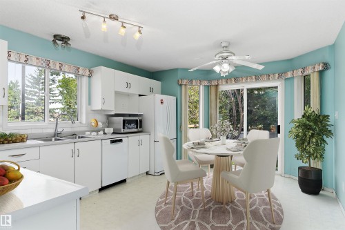 Bright kitchen with white cabinetry and countertops, featuring a stainless steel sink and a built-in dishwasher - 851 112A Street Nw, Edmonton, AB - Indoor