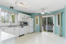 White cabinetry, stainless steel sink, track lighting, ceiling fan, and sliding glass door - 851 112A Street Nw, Edmonton, AB  - Indoor Photo Showing Kitchen With Double Sink 
