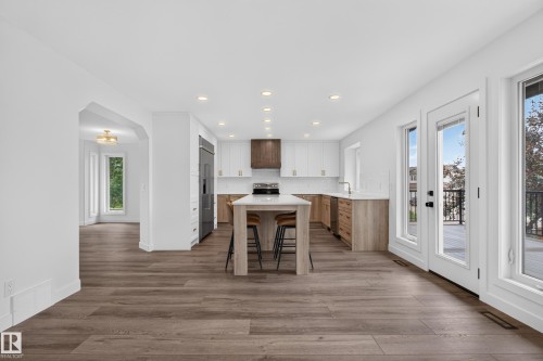 Open-concept kitchen with a central island, recessed lighting, wood-finish flooring, and white and wood-tone cabinetry - 229 Hillcrest Crest, Sherwood Park, AB - Indoor
