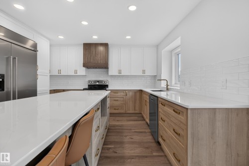 Kitchen featuring recessed lighting, stainless steel appliances, wood-finish flooring, white subway tile backsplash, and light-toned countertops - 229 Hillcrest Crest, Sherwood Park, AB - Indoor Photo Showing Kitchen With Upgraded Kitchen