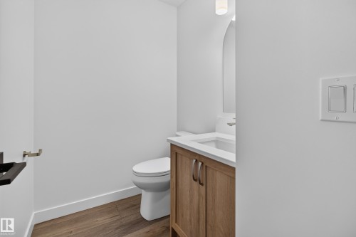 Wood-finish flooring, white walls, and a light wood vanity with a white countertop and integrated sink - 229 Hillcrest Crest, Sherwood Park, AB - Indoor Photo Showing Bathroom