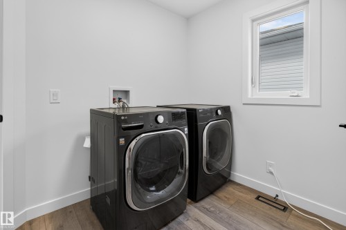 Laundry area with wood-finish flooring and a white-framed window - 229 Hillcrest Crest, Sherwood Park, AB - Indoor Photo Showing Laundry Room