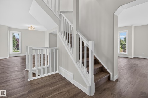 Staircase with white balusters and wood-finish treads, complemented by wood-finish flooring - 229 Hillcrest Crest, Sherwood Park, AB - Indoor Photo Showing Other Room
