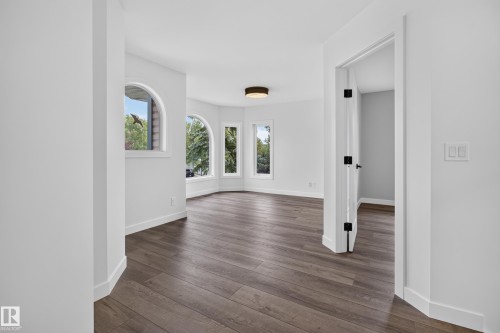 Wood-finish flooring, arched windows, recessed lighting, white walls, and a modern ceiling fixture - 229 Hillcrest Crest, Sherwood Park, AB - Indoor Photo Showing Other Room