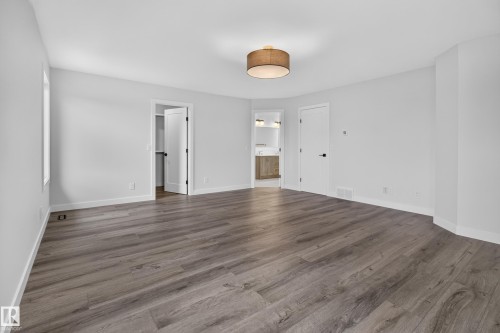 Spacious room featuring wood-finish flooring, white walls, a single window, and a drum pendant light fixture - 229 Hillcrest Crest, Sherwood Park, AB - Indoor Photo Showing Other Room
