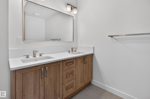 Double vanity with wood-finish cabinetry, white countertop, and dual undermount sinks - 229 Hillcrest Crest, Sherwood Park, AB - Indoor Photo Showing Bathroom