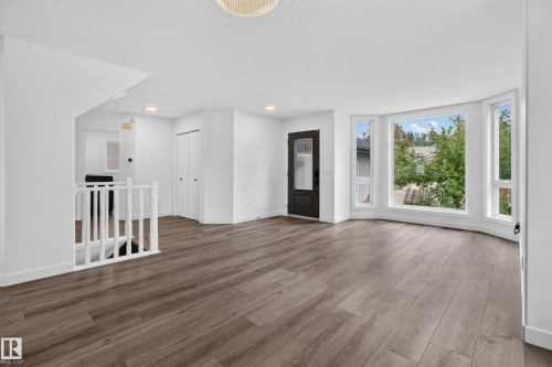 Wood-finish flooring throughout, bay windows with white trim, built-in closet with bifold doors, recessed lighting, and white baluster railing - 229 Hillcrest Crest, Sherwood Park, AB - Indoor Photo Showing Other Room