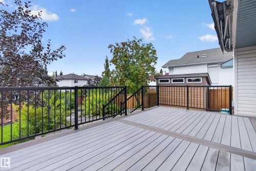 Expansive multi-tone deck with black metal railings, white siding, and a detached shed featuring multiple windows - 229 Hillcrest Crest, Sherwood Park, AB - Outdoor With Deck Patio Veranda With Exterior
