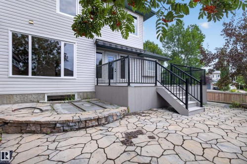 Expansive flagstone patio with a stone-clad retaining wall - 229 Hillcrest Crest, Sherwood Park, AB - Outdoor With Deck Patio Veranda