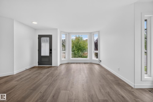 Bay window with multiple panes, wood-finish flooring, recessed lighting, and a dark-paneled door with decorative glass - 229 Hillcrest Crest, Sherwood Park, AB - Indoor Photo Showing Other Room