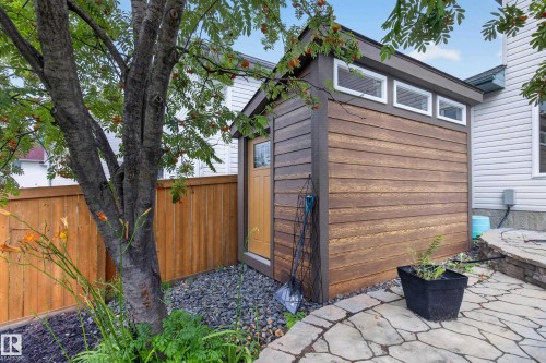 Modern backyard studio featuring horizontal wood-finish siding, large transom windows with integrated ventilation, and a natural wood entry door - 229 Hillcrest Crest, Sherwood Park, AB - Outdoor With Exterior