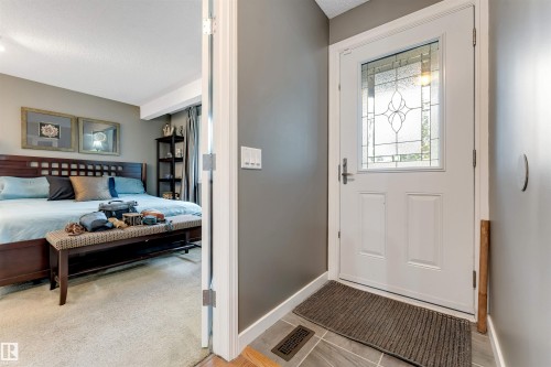 Front entry with decorative glass door, tile flooring, and neutral wall tones - 6008 37 Avenue Nw, Edmonton, AB - Indoor Photo Showing Bedroom