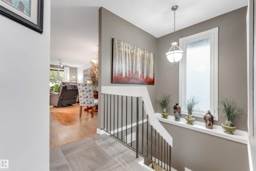 Staircase with tile flooring and black metal balusters - 6008 37 Avenue Nw, Edmonton, AB - Indoor Photo Showing Other Room